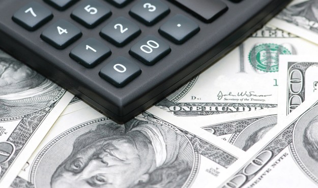 Accounting calculator over the hundred dollar bank notes